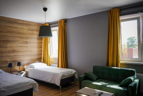 a hotel room with a bed and a green couch at Hotel Yasenki in Yasenki