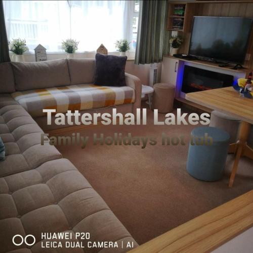 a living room with a couch and a tv at Tattershall Lakes Family Holiday Hot Tub break in Tattershall