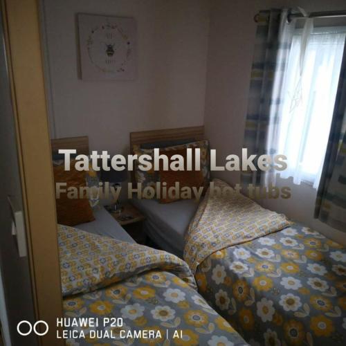 塔特舍爾的住宿－Tattershall Lakes Family Holiday Hot Tub break，卧室的倒影,设有两张床和一扇窗户