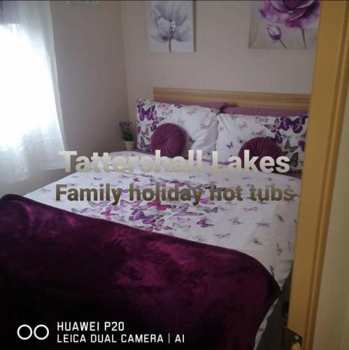 a bedroom with a bed with flowers on it at Tattershall Lakes Family Holiday Hot Tub break in Tattershall