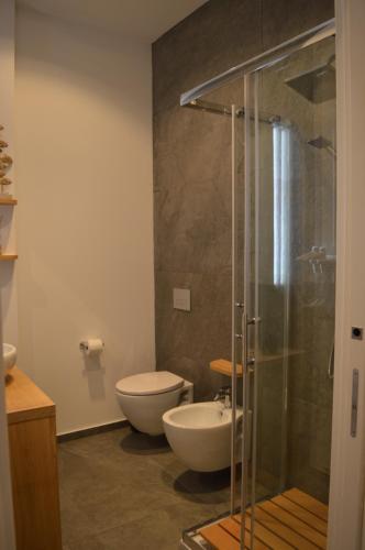 a bathroom with a toilet and a glass shower at Bed and breakfast Villa Tota in Catanzaro Lido