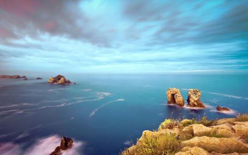 a view of the ocean with rocks in the water at Calas De Liencres in Liencres