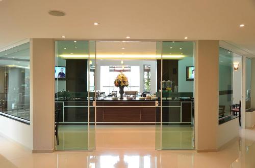 a lobby with glass doors and a vase of flowers at Hotel Matão By Mercure in Matão