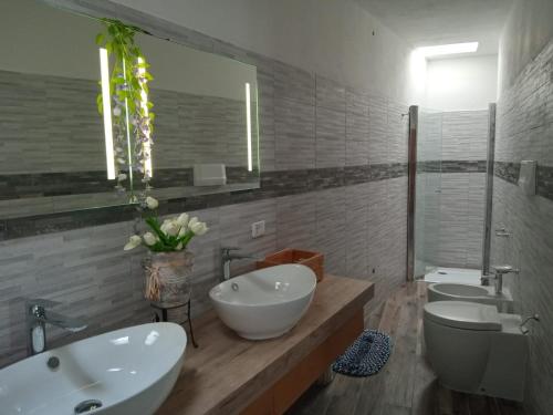 a bathroom with two sinks and two toilets at Dammuso Dell`Angelo in Pantelleria