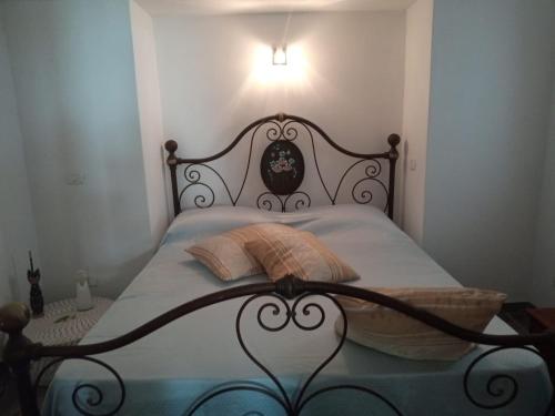 a bedroom with a bed with a black head board at Dammuso Dell`Angelo in Pantelleria