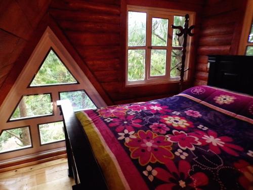 a bedroom with a bed with flowers on it at Cabañas El Rincón de Pancho in Altotonga
