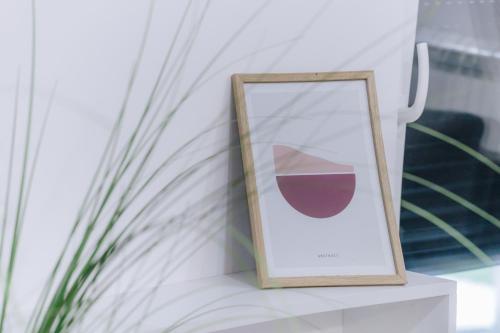 a picture in a wooden frame sitting on a table at LUST PREMIUM Apartments in Kragujevac