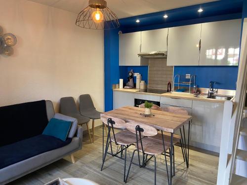 un salon avec une table et un canapé dans l'établissement maison des résidences de la mer, à Courseulles-sur-Mer