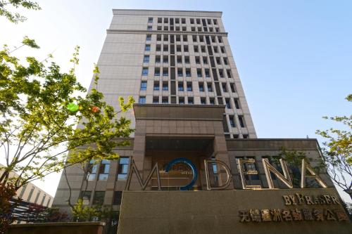 a sign in front of a tall building at Modena By Fraser New District Wuxi in Wuxi