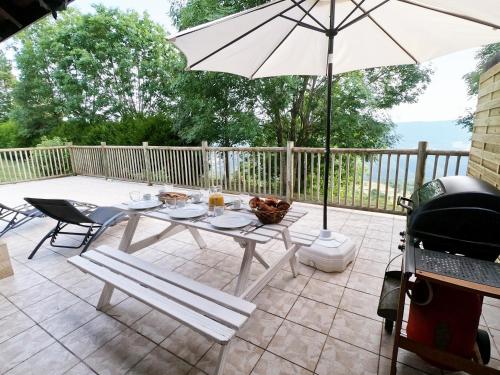 a table and chairs and an umbrella on a patio at L'Orée des Pignes in Nojaret