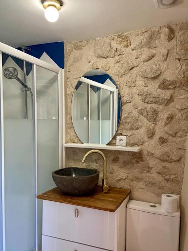 une salle de bain avec un lavabo et un miroir dans l'établissement Le Clos Gallien - Maison coucoute, à Illats