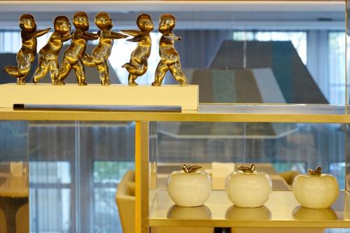 a shelf with a group of gold figurines on it at Modena By Fraser New District Wuxi in Wuxi