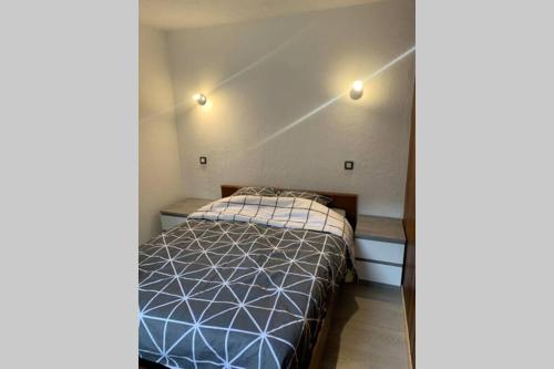 - une petite chambre avec un lit et deux tables dans l'établissement Superbe appartement avec parking gratuit sur place, à Bourg-Saint-Maurice