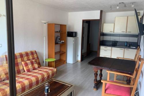 a living room with a couch and a table at Superbe appartement avec parking gratuit sur place in Bourg-Saint-Maurice