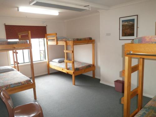 a room with three bunk beds and a window at Launceston Backpackers in Launceston