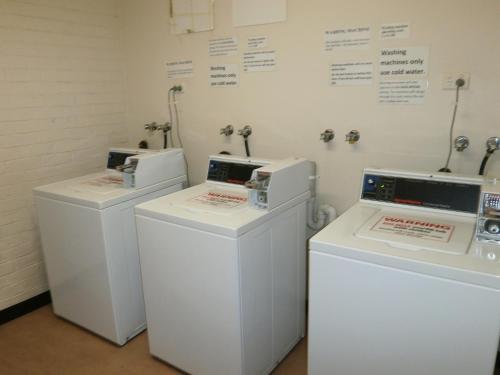 three washing machines are lined up in a room at Launceston Backpackers in Launceston