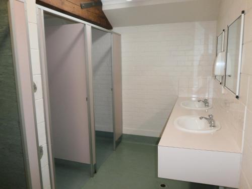 uma casa de banho com 2 lavatórios e um chuveiro em Launceston Backpackers em Launceston