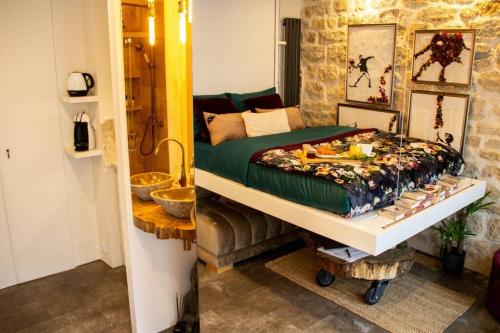 - une chambre avec un lit et un mur en pierre dans l'établissement Tiny Gallery Paris Gare Montparnasse, à Paris
