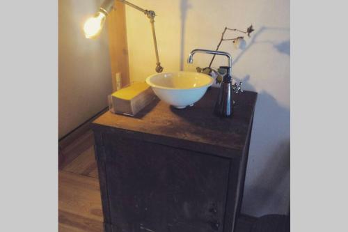 a bathroom with a bowl sink on a counter at 呼子の港路地の古民家一棟貸切宿梵soyogi in Karatsu