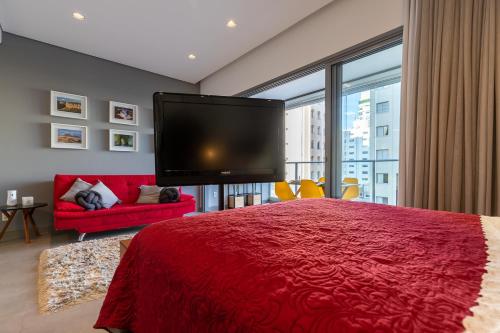 a bedroom with a large red bed and a flat screen tv at Loft em Moema, próximo ao Metro, com estacionamento no condomínio in Sao Paulo