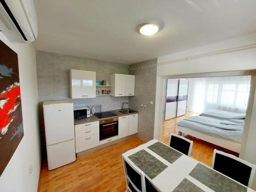 a kitchen with white cabinets and a table and a bed at Accommodation Kolar City center Zabok in Zabok