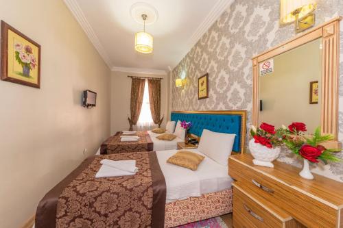 a hotel room with two beds and a mirror at Ista Palace Hotel in Istanbul