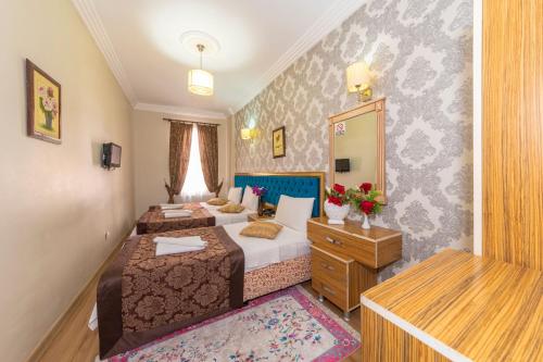 a bedroom with two beds and a dresser at Ista Palace Hotel in Istanbul