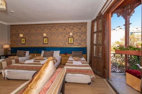 a hotel room with four beds and a balcony at Ista Palace Hotel in Istanbul