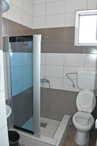 a bathroom with a toilet and a glass shower at Apartments Murati in Ulcinj