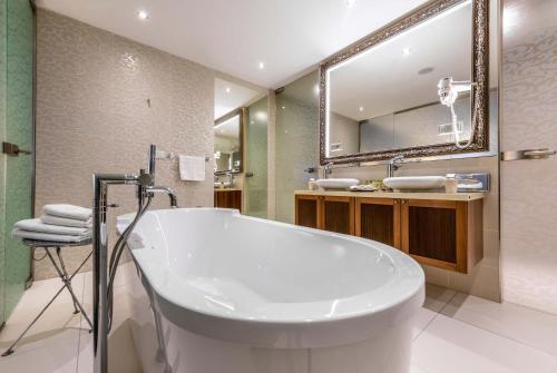 a bathroom with a tub and a large mirror at Hotel Elizabeth in Trenčín