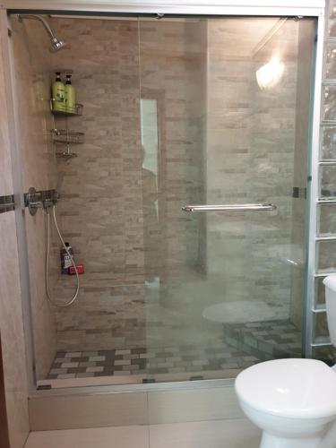 a bathroom with a glass shower with a toilet at Villa 2527 San Lameer in Southbroom