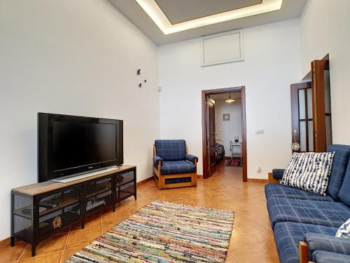 a living room with a tv and a blue couch at Casa Refugio Do Campo in Reguengos de Monsaraz