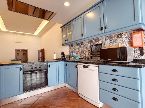 a large kitchen with blue cabinets and appliances at Casa Refugio Do Campo in Reguengos de Monsaraz