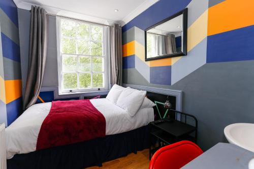 a colorful bedroom with a bed and a window at KX Rooms Kings Cross in London
