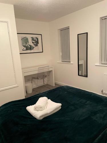 a bedroom with a green bed with a mirror at Lovely 2 bed house Cannock Driveway for 2 vehicles Perfect for contractors Business Travellers Short Stays Close to M54 M6 i54 A38 A5 McArthur Glen Designer Outlet in Cannock