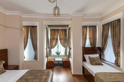 una camera con due letti e finestre di Grey House Hotel a Istanbul