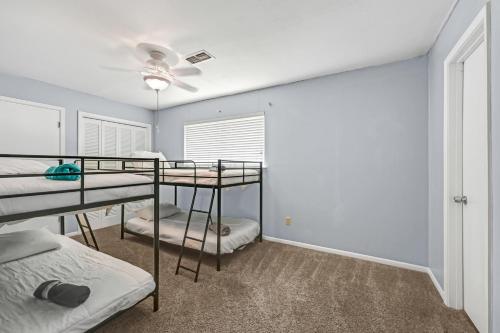 a bedroom with three bunk beds and a window at Home for summer with pool, pool table, outdoor kitchen,patio and balcony in Houston