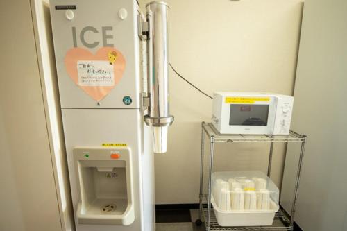 a refrigerator with a ice machine and a microwave at AZ Inn Handa Inter in Handa