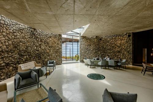 a restaurant with a stone wall and tables and chairs at Radisson Resort and Spa Lonavala in Lonavala