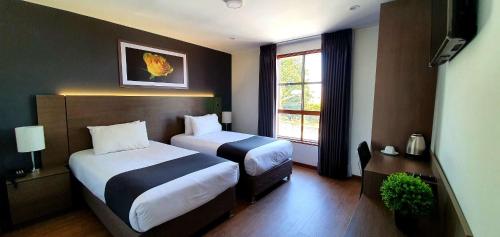 Habitación de hotel con 2 camas y ventana en Vita Hoteles Arequipa, en Arequipa