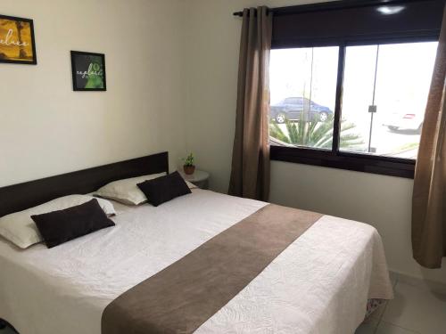 a bedroom with a large bed with a window at Apto Beira Mar 3D in Capão da Canoa