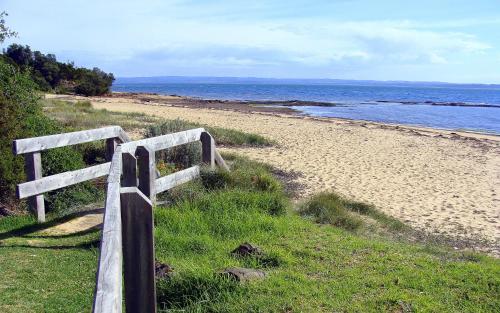 a wooden fence on the side of a beach at NRMA Phillip Island Beachfront Holiday Park in Cowes