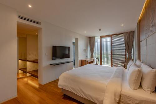 a bedroom with a large bed and a television at Radisson Resort and Spa Lonavala in Lonavala