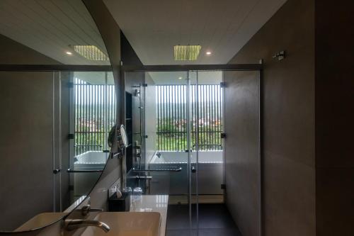 a bathroom with a glass shower and a sink at Radisson Resort and Spa Lonavala in Lonavala