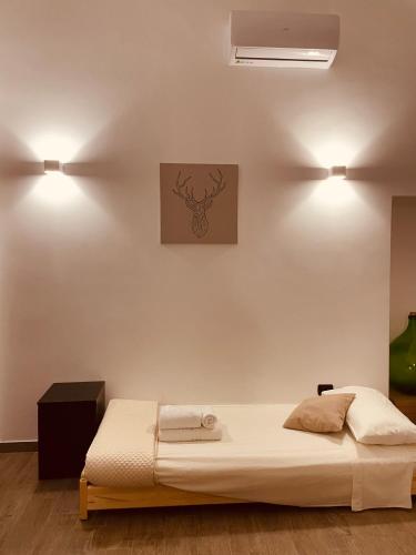 a bed in a room with two lights on the wall at L’angolo delle bugie in Turi