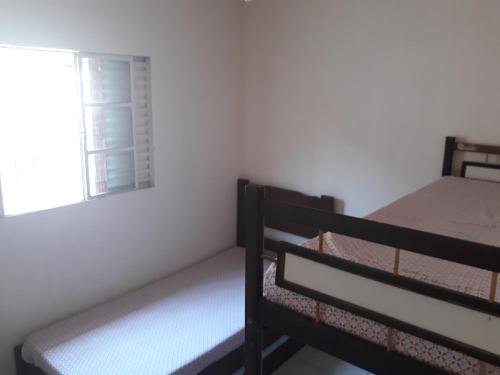two bunk beds in a room with a window at Aconchegante casa para temporada in Mongaguá