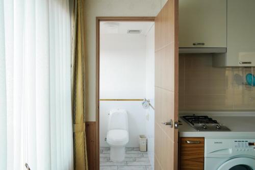 a small kitchen with a toilet and a sink at Jungmun Haesung Parktel in Seogwipo