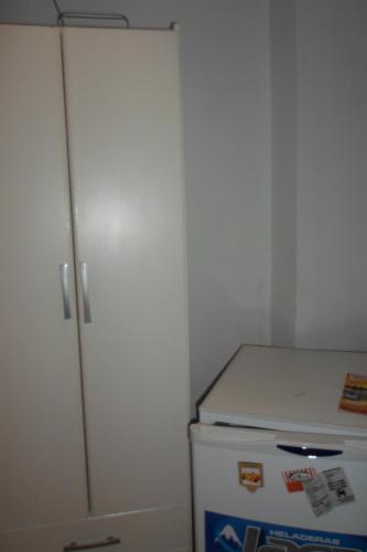 a kitchen with a white cabinet and a refrigerator at La Casona de Susana in Colón
