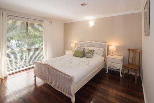 a bedroom with a white bed and a window at Down Town Margaret River in Margaret River Town