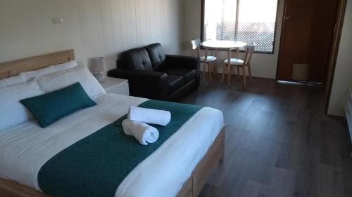 a hotel room with a bed, couch, and table at Yarrawonga Riverlands Tourist Park in Yarrawonga